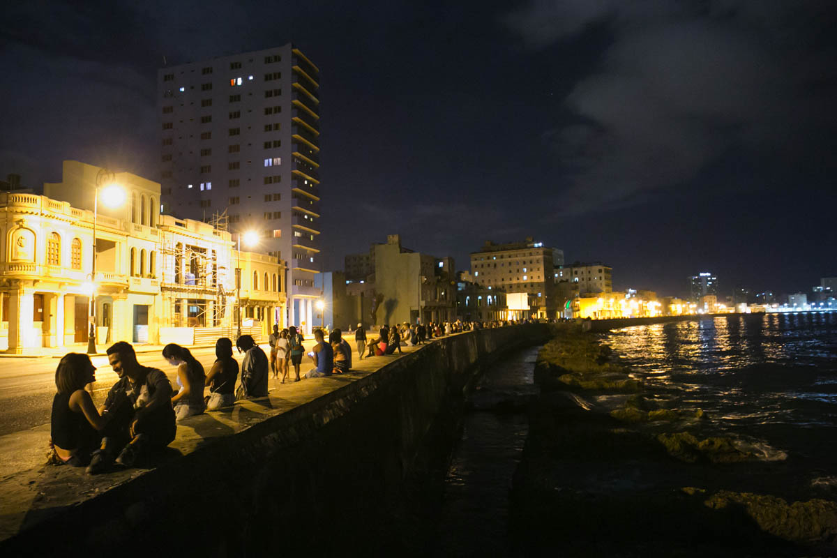 Cubans hang out along the Malecón in Havana after midnight, playing music, drinking and chatting.