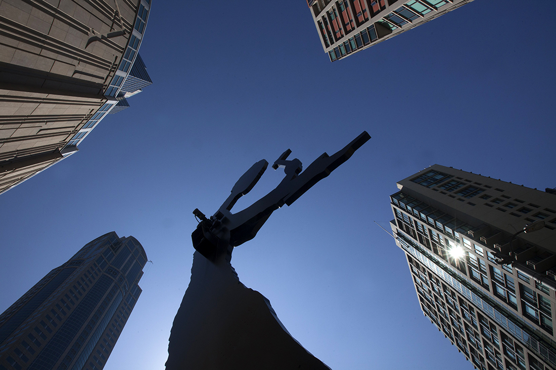 The Johnathan Borofsky-designed Hammering Man swings his arm at the corner of First Avenue and University Street, in front of the Seattle Art Museum and near the University Street Station. (Ellen M. Banner / The Seattle Times)