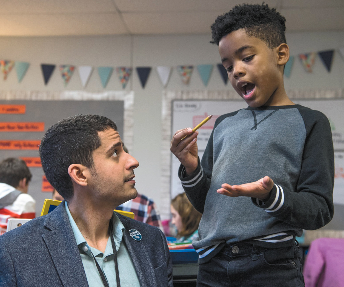 Adam Aguilera helps fourth-grader Kaler Mathews with a question