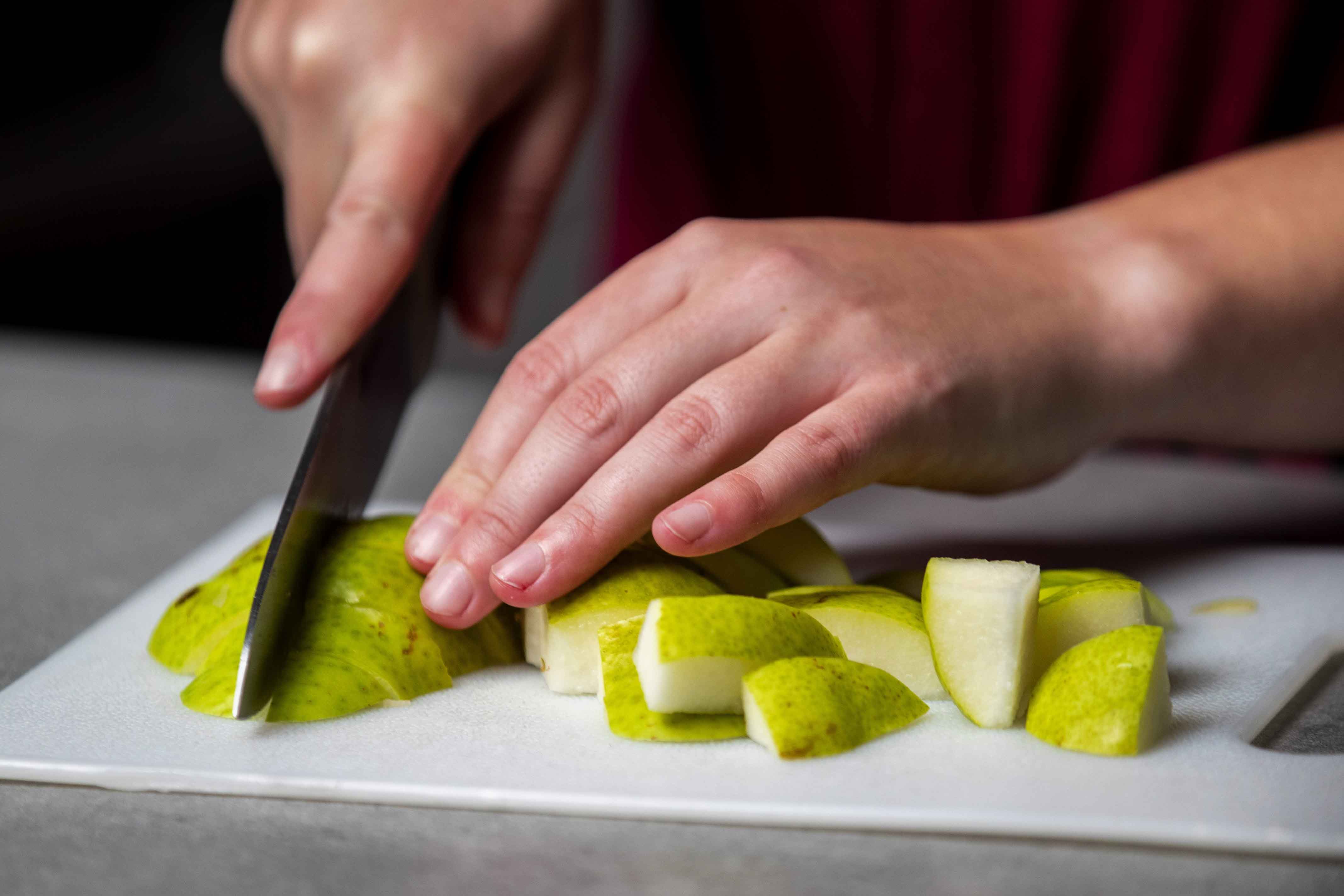 Slicing up green pears into small cubes for the cranberry-pear pie filling.