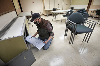 Fred Wilkins, an HVAC technician with Highline Public Schools’ facilities department, replaces a filter to provide cleaner air in a room at Chinook Middle School in SeaTac on April 9. The Centers for Disease Control and Prevention advises that schools ensure that air filtration and ventilation systems are working at max capacity to curb the spread of COVID-19. (Ellen M. Banner / The Seattle Times)