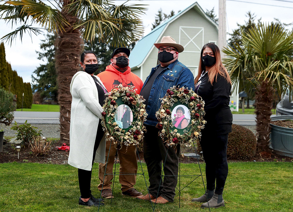 From left, siblings Cookie Schleppy, Jerry Sanchez, Cris Sanchez and Anita Meadows hold memorials to their late parents in Mount Vernon. Their mother, Nena, loved palm trees and rose bushes. (Erika Schultz / The Seattle Times)