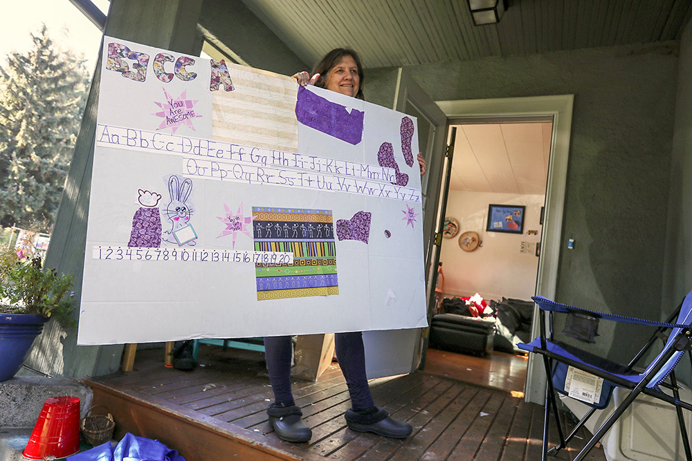 Karla Petersen, of Seattle, displays a table divider used by one of her younger children. Leaving in-person school last spring disrupted Petersen’s family of 8. During summer, the family spent time together, often outside, connecting with each other. (Ken Lambert / The Seattle Times)