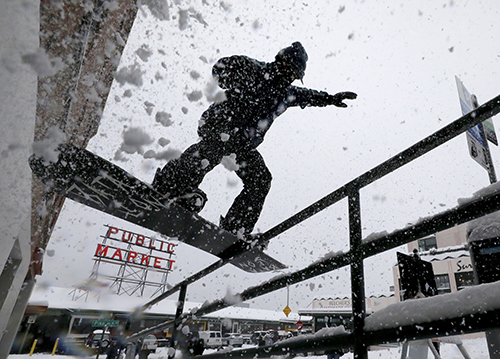 During a rare snowfall in Seattle, I thought I’d check out Pike Place Market. As I turned the corner at Pike Street, snowboarder Max Djenohan was doing tricks on a handrail. I headed down a stairwell for a better angle. His friends monitored the sidewalk. The street was closed. Snow flew.