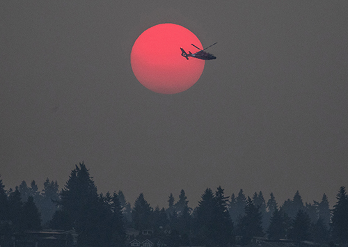 In photography, it’s critical to have luck on your side. But you also have to be ready, to anticipate a lucky moment. While I was out at sunrise to shoot smoky, hot weather, a Coast Guard helicopter was circling Lake Washington. It flew right into the perfect spot, so ... dial-a-photo.