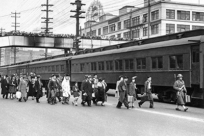 Crowds jam Seattle’s Marion Street pedestrian overpass to witness the U.S. Army’s mass removal of all Japanese American residents of Bainbridge Island on March 30, 1942. Soldiers had led them onto the ferry, and in Seattle they were put on a train bound for California. The Times did not publish this picture then. (The Associated Press)