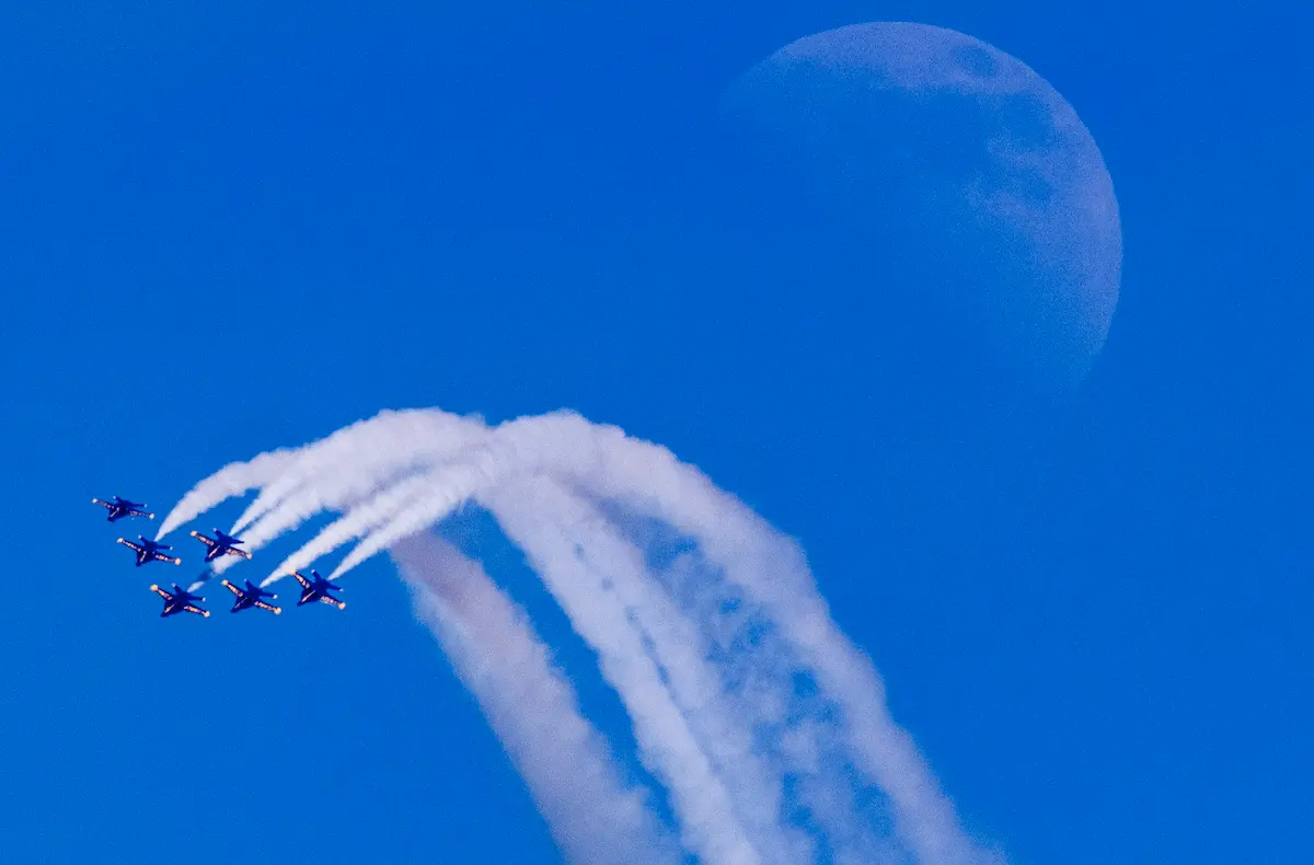 The Blue Angels perform a team maneuver as they fly over Seattle for the 72nd Seafair. I was at Kerry Park hand-holding a very long, prime lens, hoping to get a unique picture of the Blue Angels. I was really excited to get a picture of them near the Space Needle, but I was not able to get them close enough in the frame. With the help of an astute photographer pointing to the moon, I realized that was the shot. Every time they passed by the moon, I took a few frames; this was the one that lasted.