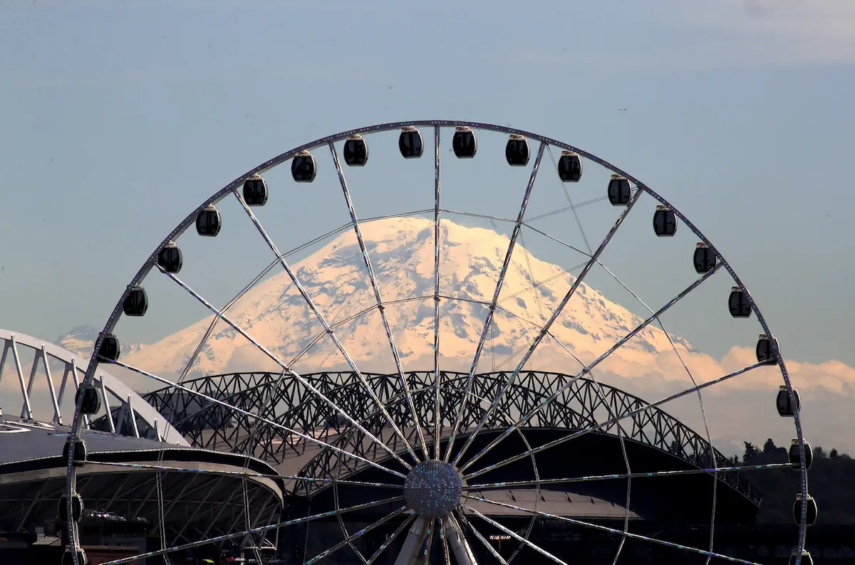 Ever since the Seattle Great Wheel was built, I have visualized it with Mount Rainier framed within. There always were roadways and buildings in the way, but after the viaduct was taken down, I realized my access was no longer blocked. I had parked near Pike Place Market, walking to an assignment where the viaduct exit ramp once stood. There was my photo. I had to carefully step over dirt and construction equipment to frame the photo. Mount Rainier was out in full beauty: no haze, noclouds. I used a 400 mm lens, hand-held at a high shutter speed.