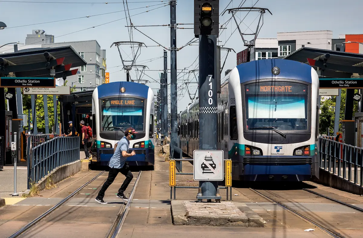 When a man ran in front of a stopped, unloading south-bound light-rail train at the Othello station to catch a northbound train (at right), I knew I had the front-page photo. It was for Mike Lindblom’s story about the dangers and fatalities of Sound Transit’s surface tracks south of downtown Seattle. But getting to this point took two photojournalists days of observing the stations during different times. The original idea was to cover the areas during the afternoon commute. I took over coverage at midmorning, with pedestrians standing at faded crosswalks near train tracks, navigating traffic signals, flashing warning signs and loud train alerts along one of the city’s busiest streets.