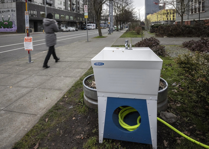 Starting in November 2020, the Seattle City Council earmarked $100,000 to quickly set up dozens of new outdoor sinks around the city to support homeless residents’ hygiene needs. By the end of 2021, only two sinks had been installed, including this one, which is located outside of University Heights Center in University District. (Steve Ringman / The Seattle Times)